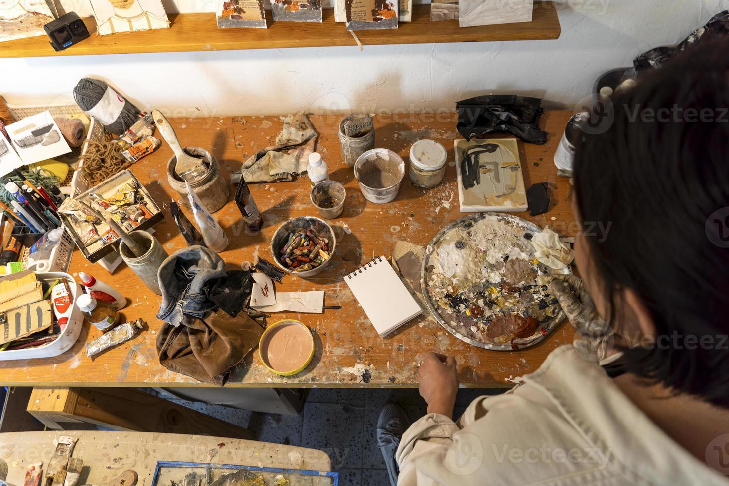 joven mujer latina, en su propio estudio de pintura, crea pinturas diferentes técnicas artísticas foto