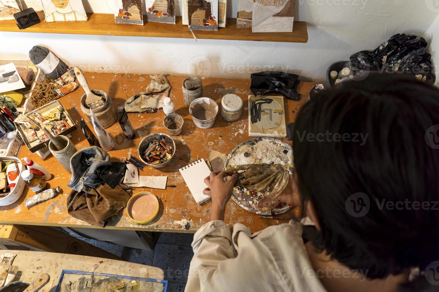 taller de artistas. lienzo, pintura, pinceles, espátula sobre la mesa. foto