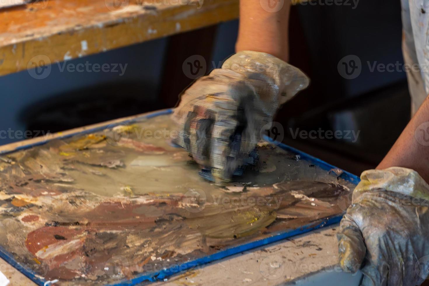 Artists workshop. Canvas, paint, brushes, palette knife lying on the table. photo