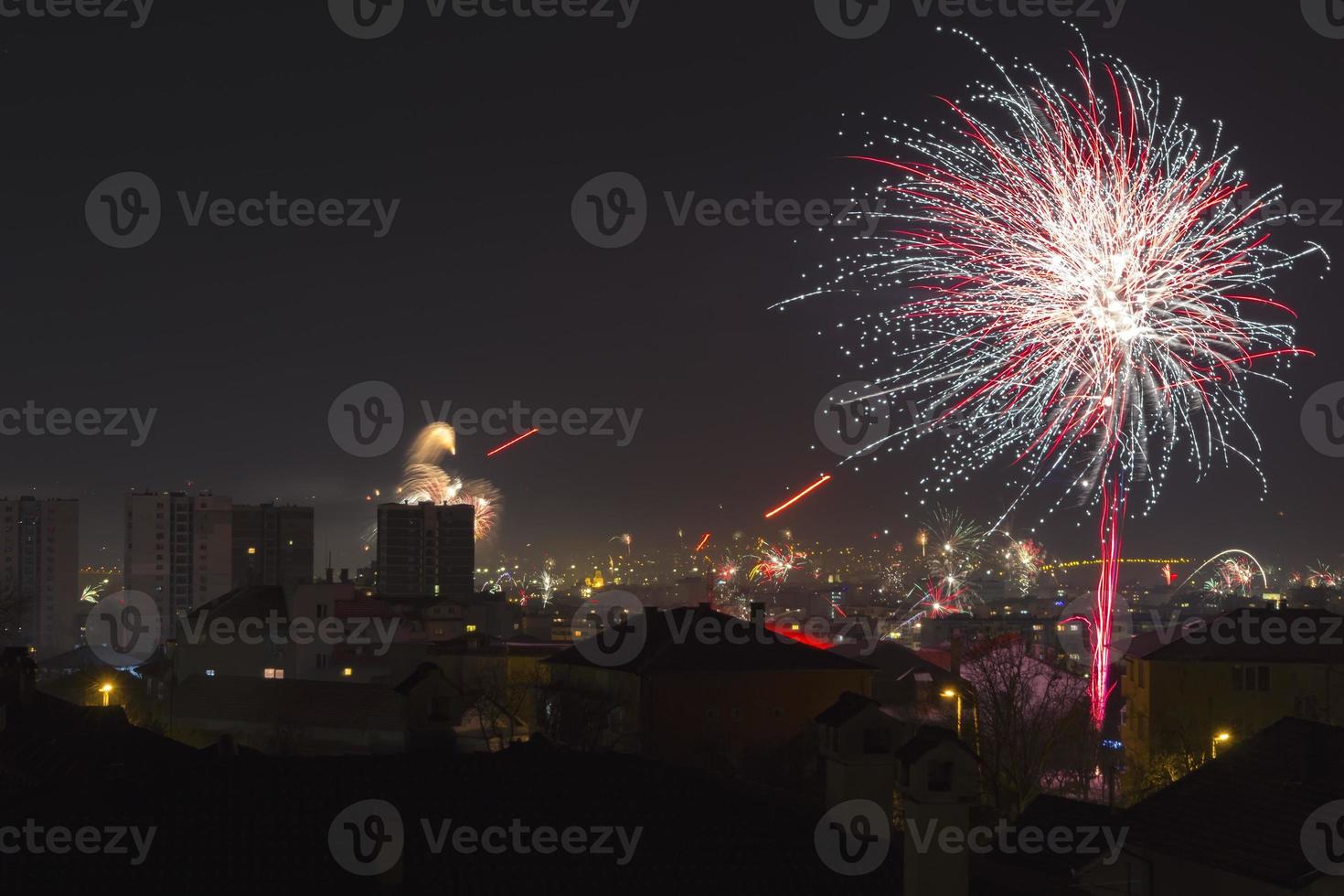 Colorful fireworks celebration and the city night light background. photo