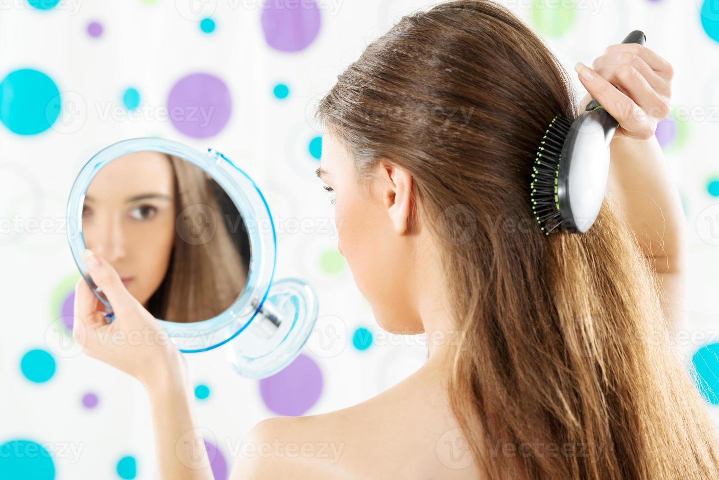 Girl With A Mirror Combing Her Hair photo