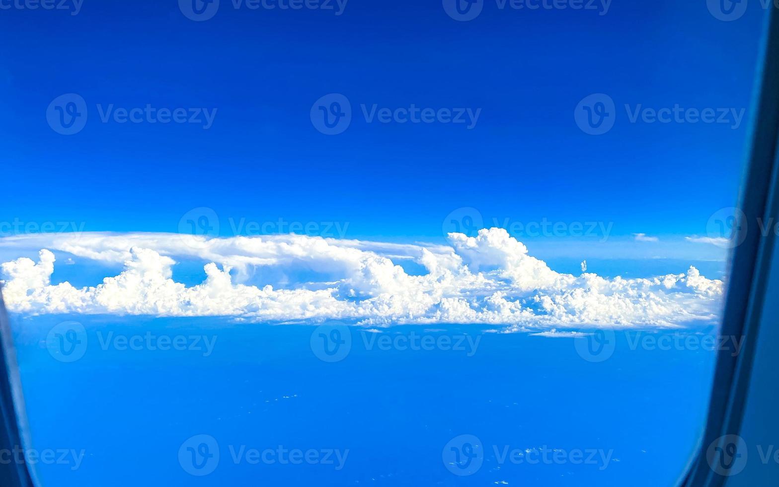 Flying above the clouds with view from the plane window. photo