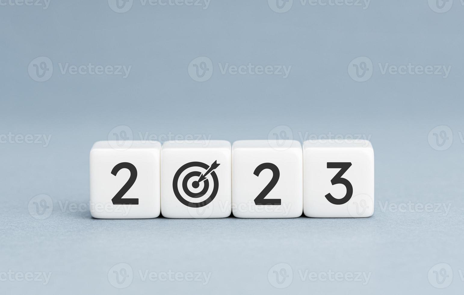 2023 year goal concept. White blocks with 2023 number and goal target icon on blue background. Copy space photo