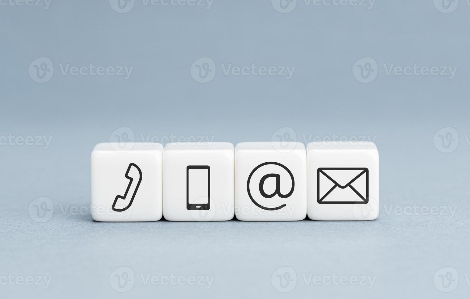 Contact us icons on white cube blocks on blue background. Copy space photo