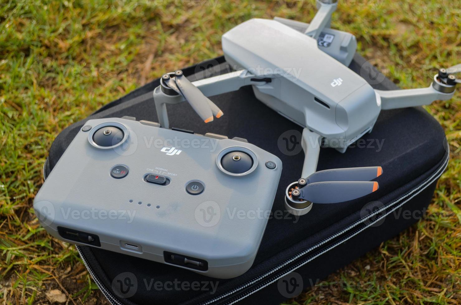 MALANG, INDONESIA - November 6th 2022, Top view of the grey DJI Mini 2 drone and remote above the bag and in nature photo