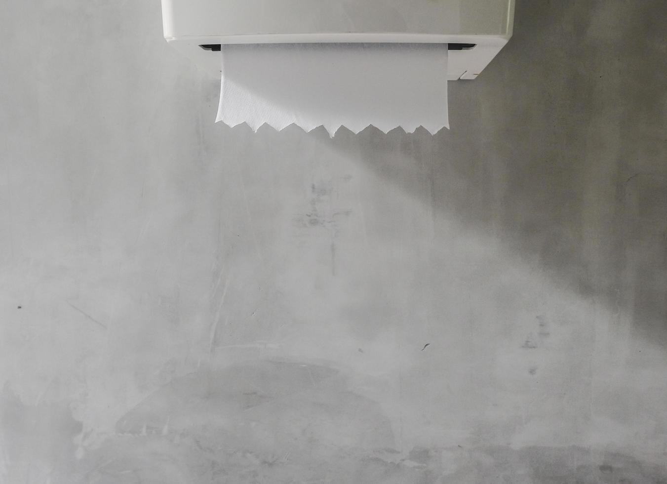 Toilet tissue box on loft grey wall with nature light and shadow background, copy space. photo