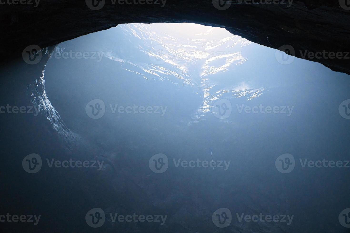 Rock cave with hole through which light shines. Underworlds in Sweden. Mystical photo