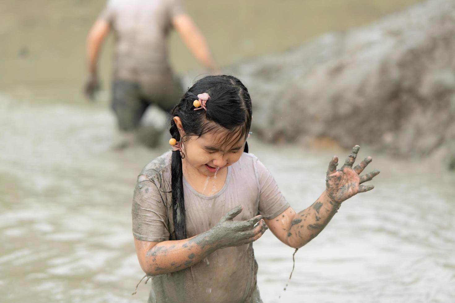 Little girls have fun playing in the mud in the community fields photo