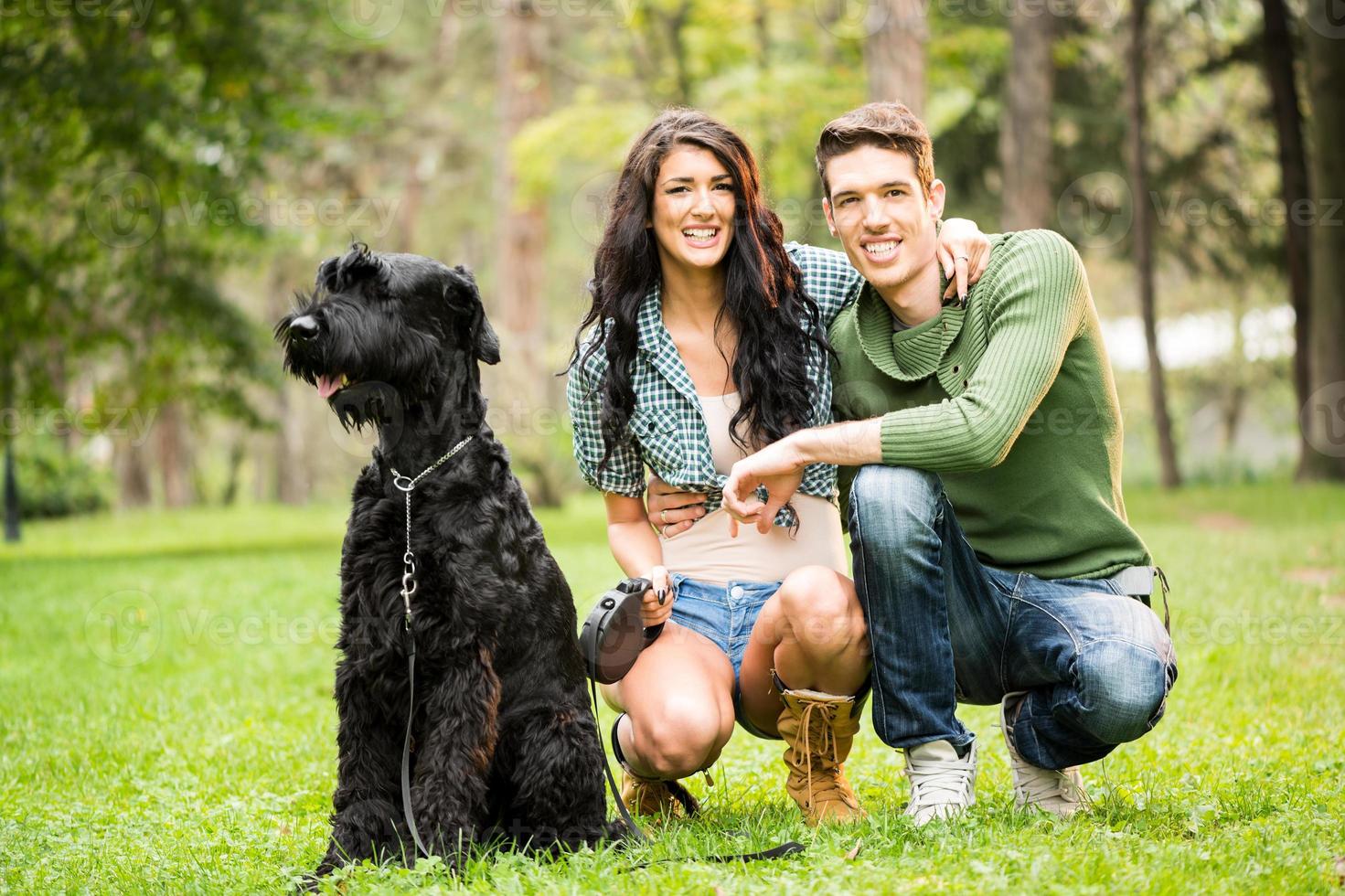Young Couple With Black Giant Schnauzer photo