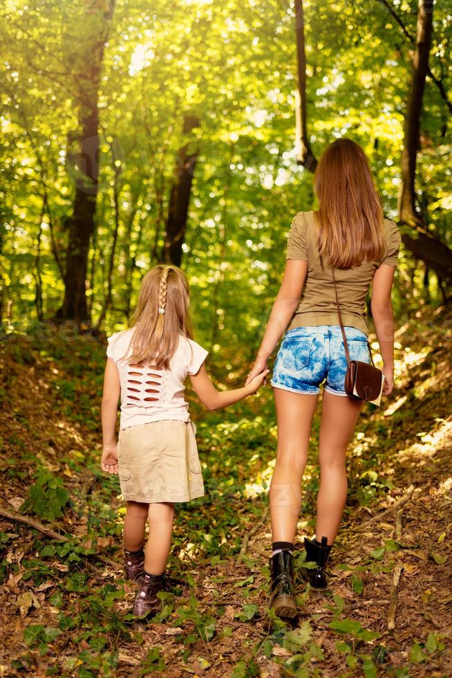 mujer joven y niña en el bosque foto