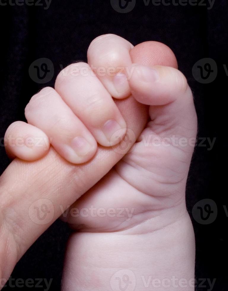 baby hand on a black background photo