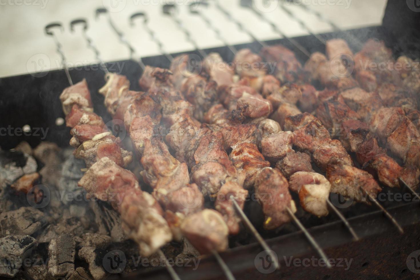 Meat is fried outside. Raw meat planted on blades. Heating food on