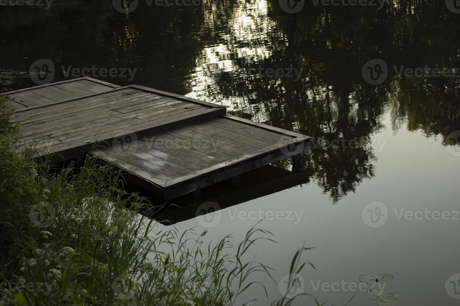 Marina on lake. Empty wharf of boards. Small berth for collecting water from pond. photo