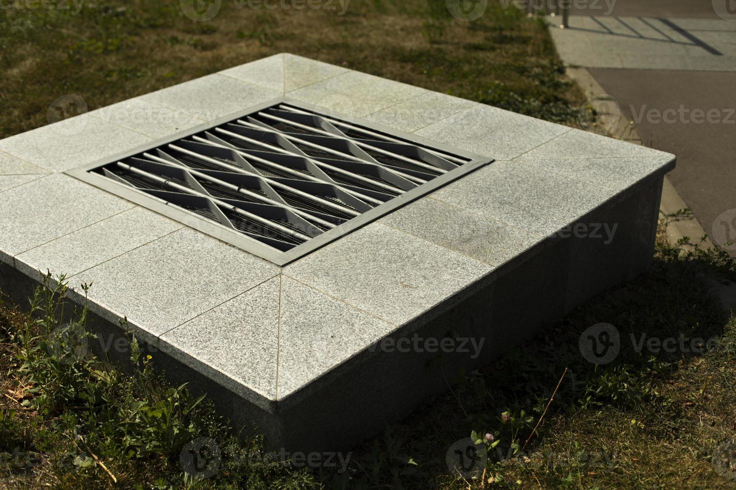 Ventilation hatch in city. Grille for ventilation. Infrastructure on street. photo