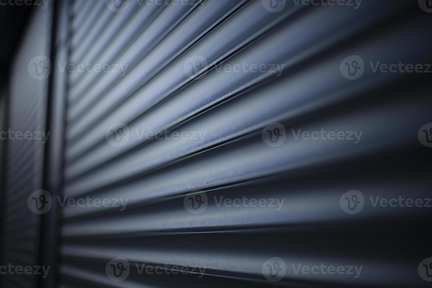 Blinds on windows of store. Steel blinds for large windows. Ribbed surface against wall. photo