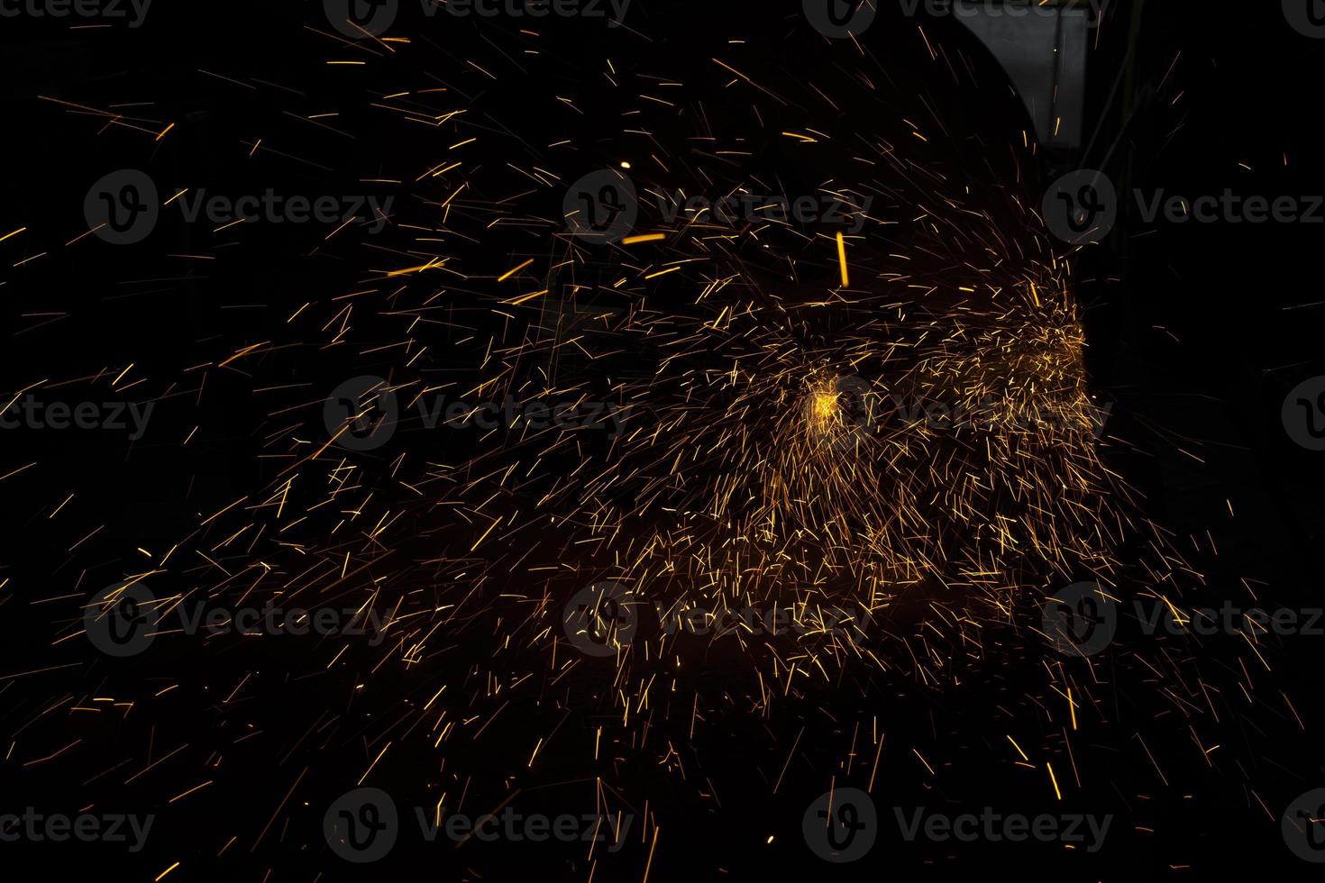 Lights in dark. Sparks from sawing metal. Industrial background. photo