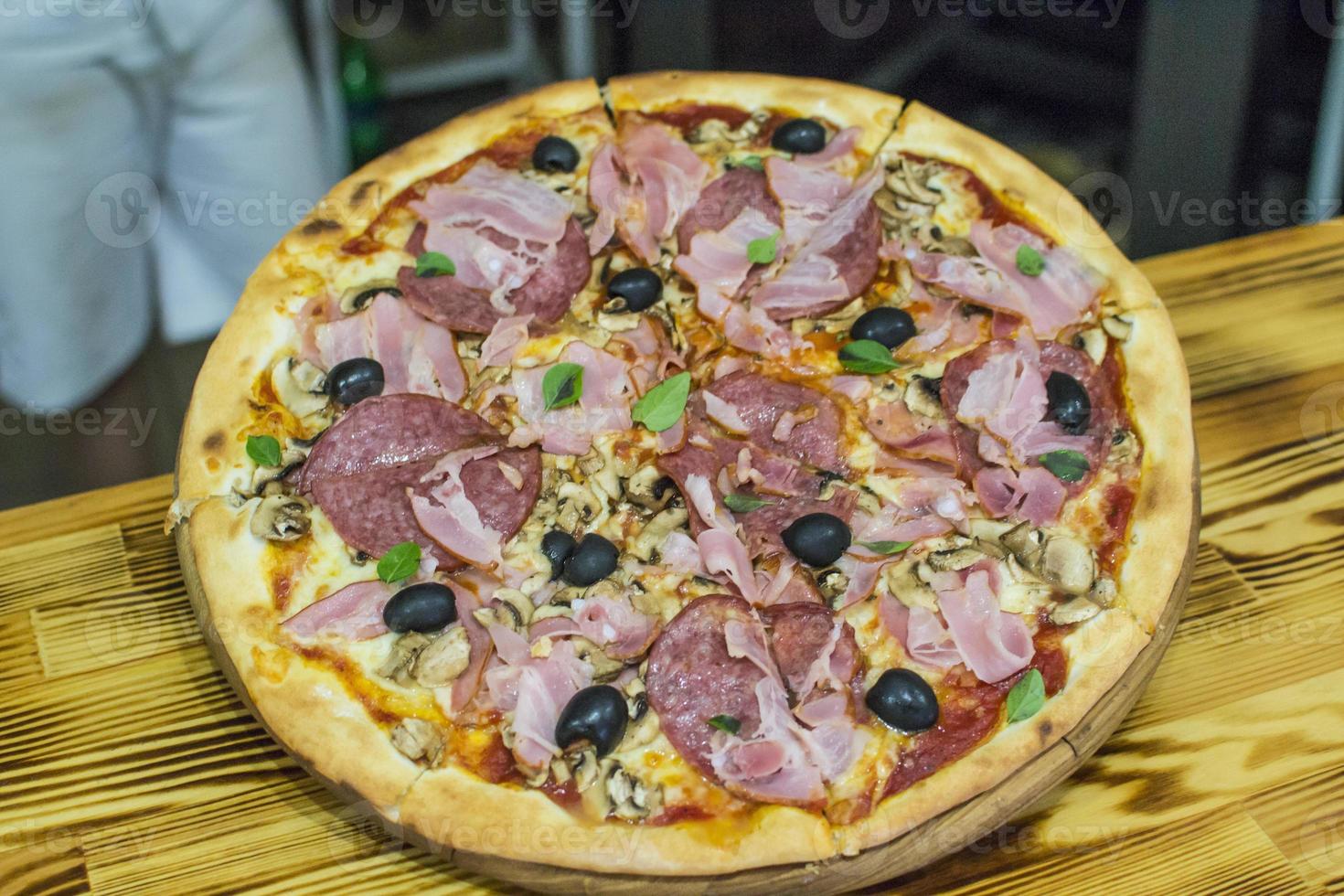 pizza cerca de la estufa de piedra con fuego. fondo de un restaurante pizzería tradicional con chimenea. foto