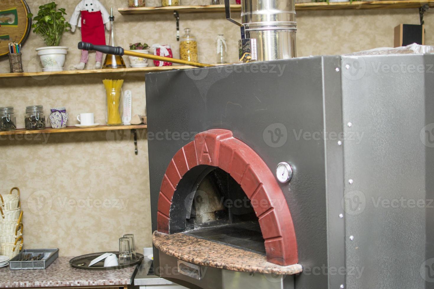 Pizza near the stone stove with fire. Background of a traditional pizzeria restaurant with a fire place. photo