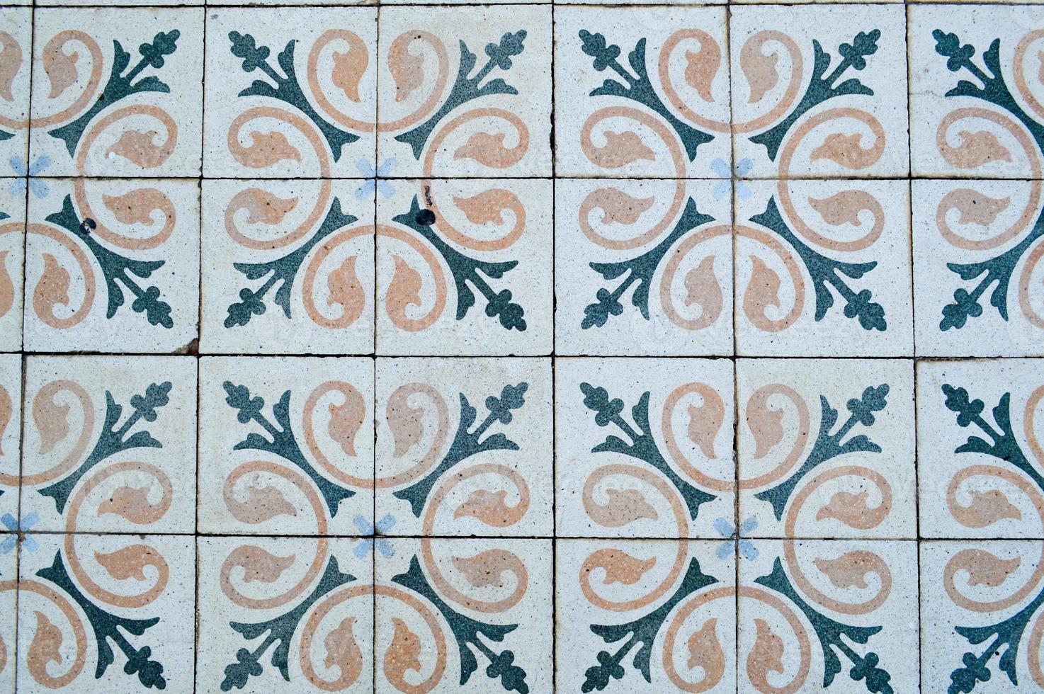 The texture of square ceramic tiles with patterns from traditional Arabic ornaments and flowers of yellow and blue with seams. The background photo