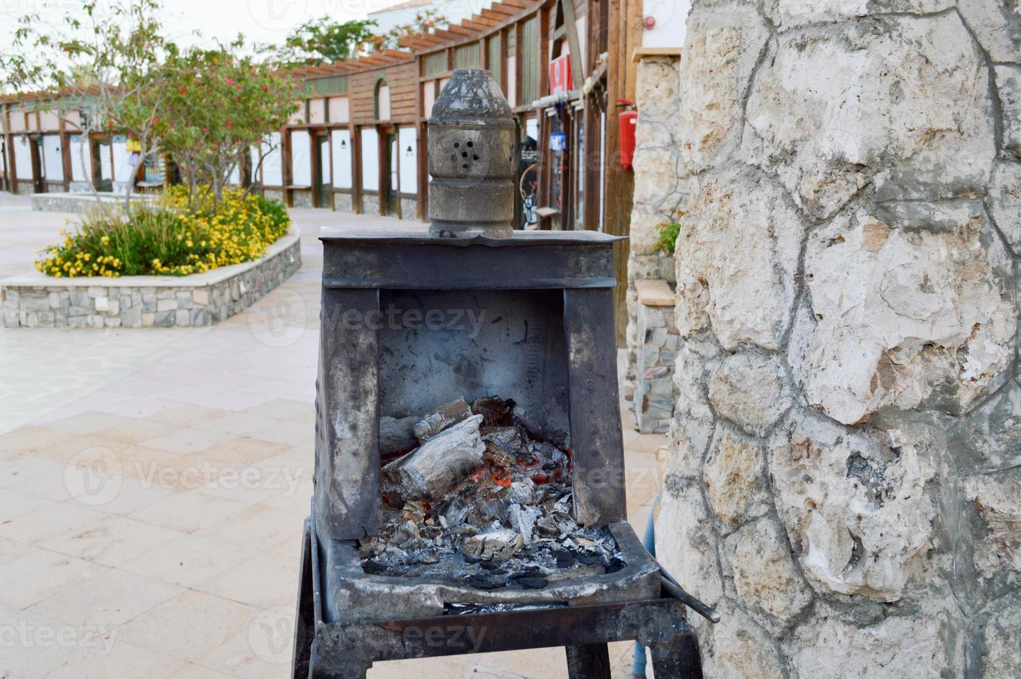 Special iron black metal oven, brazier for the preparation of hot, uncoiled coals for a traditional hookah in Egypt photo