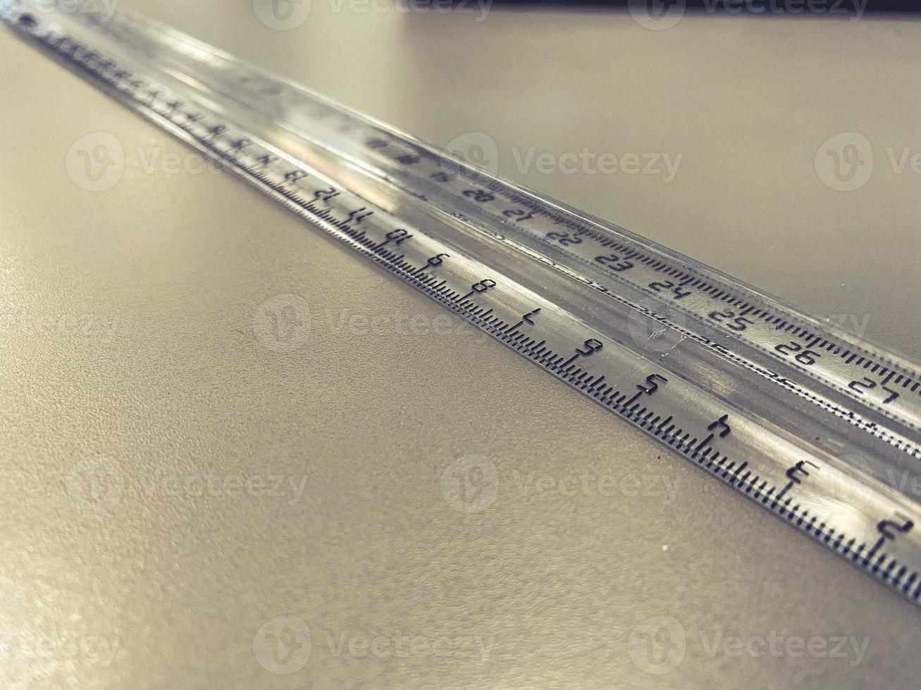 a transparent, long, centimeter ruler lies on the table. supplies for mathematics and geometry. measuring tool. stationery for office and schoolchildren photo