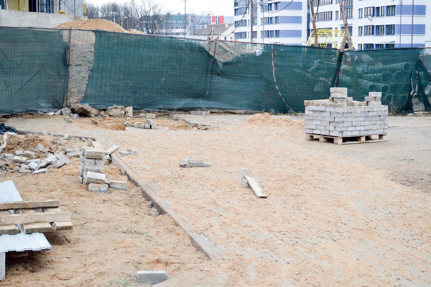 A mess at a construction site with scattered building materials and rubbish with dirt, poor safety precautions, unsanitary conditions and environmental pollution at an industrial construction site photo