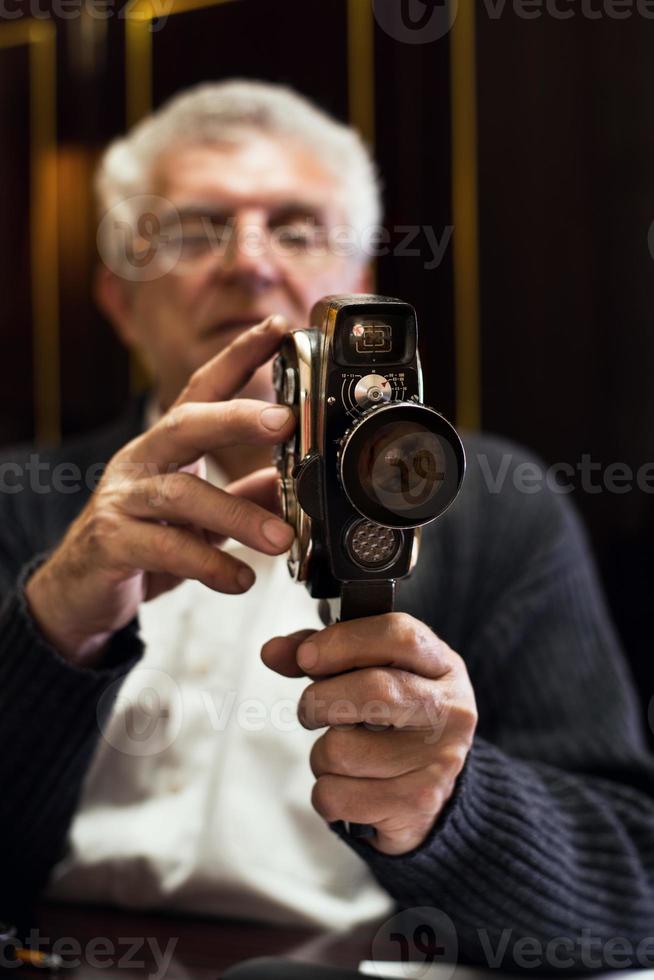 hombre mayor que sostiene la cámara de video foto