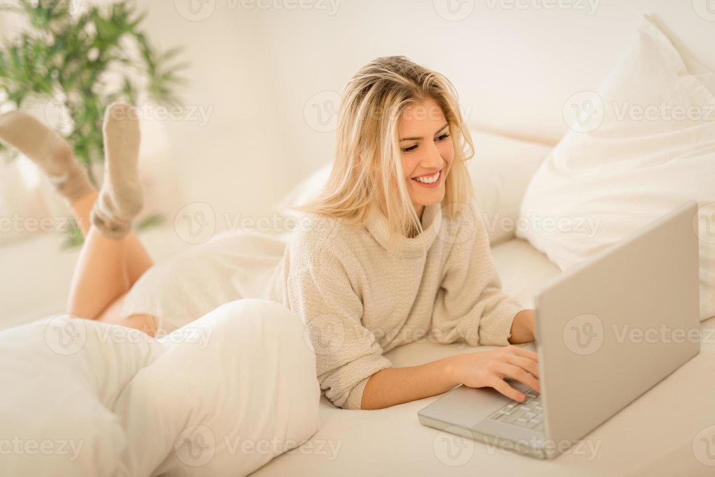 Girl Using Laptop In Bed photo