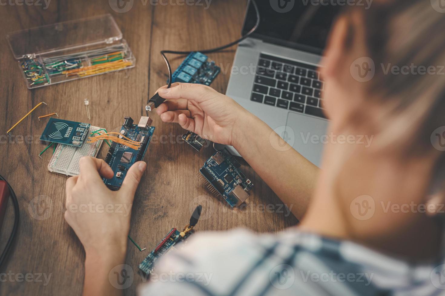 Female Engineer Testing Circuit Board In Her Office photo