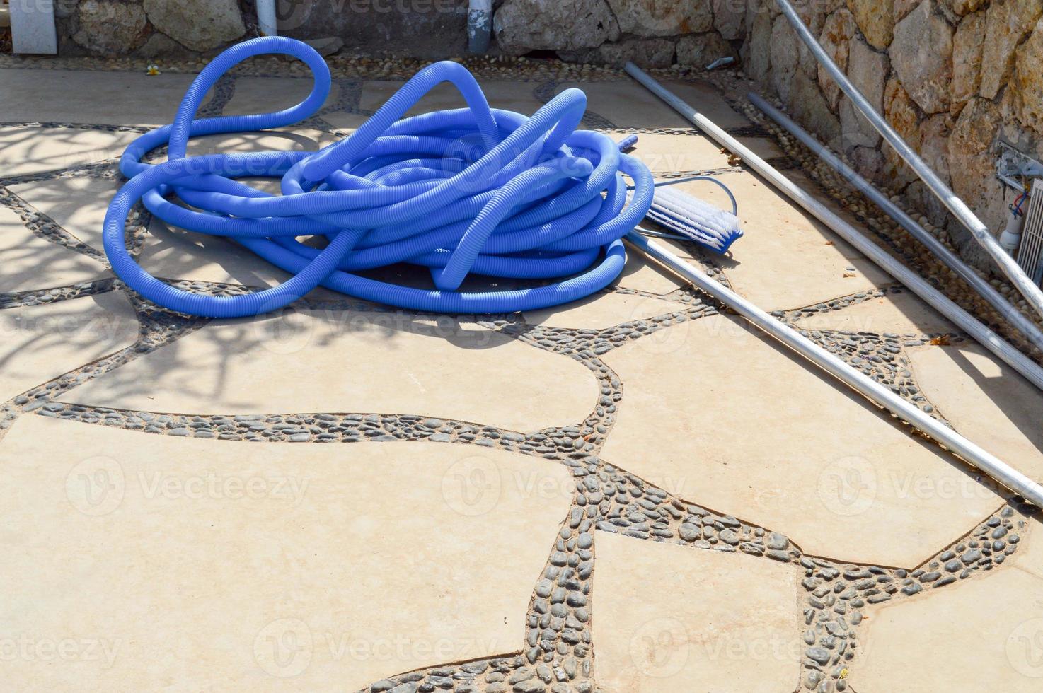 Blue plastic long large corrugated hose for cleaning the pool wash and watering the plants photo