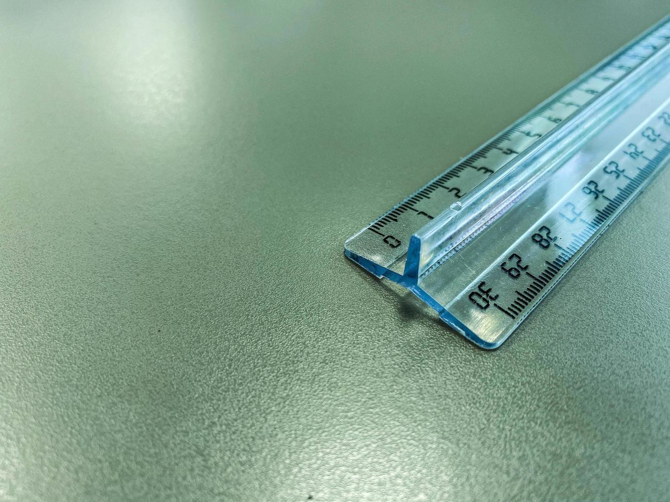 a transparent, long, centimeter ruler lies on the table. supplies for mathematics and geometry. thin ruler with markings with centimeter measurements photo