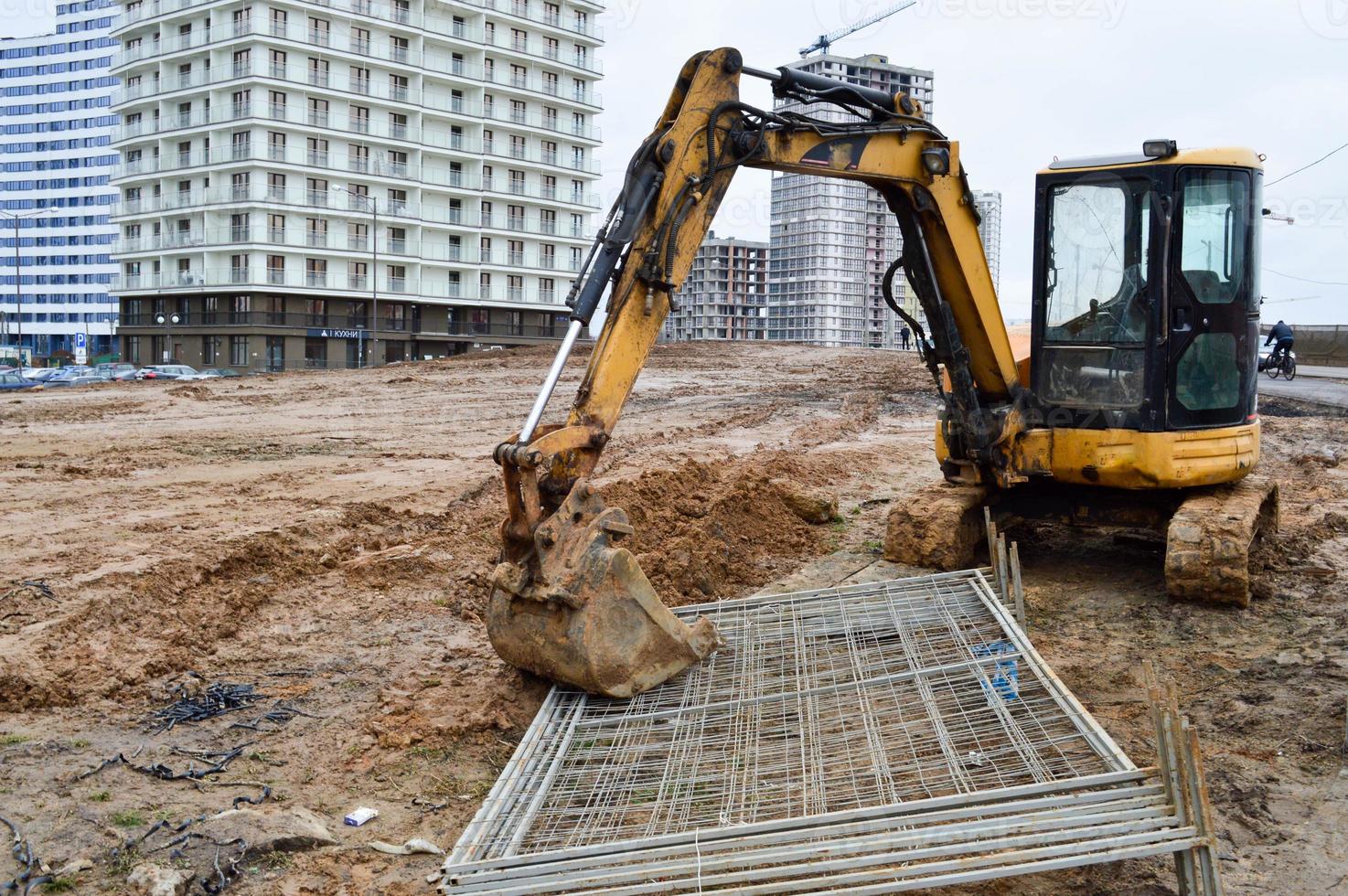 tractor de excavadora pesada industrial de gran alcance amarillo brillante, bulldozer, equipo de construcción especializado para la reparación de carreteras durante la construcción de un nuevo microdistrito en una gran ciudad foto