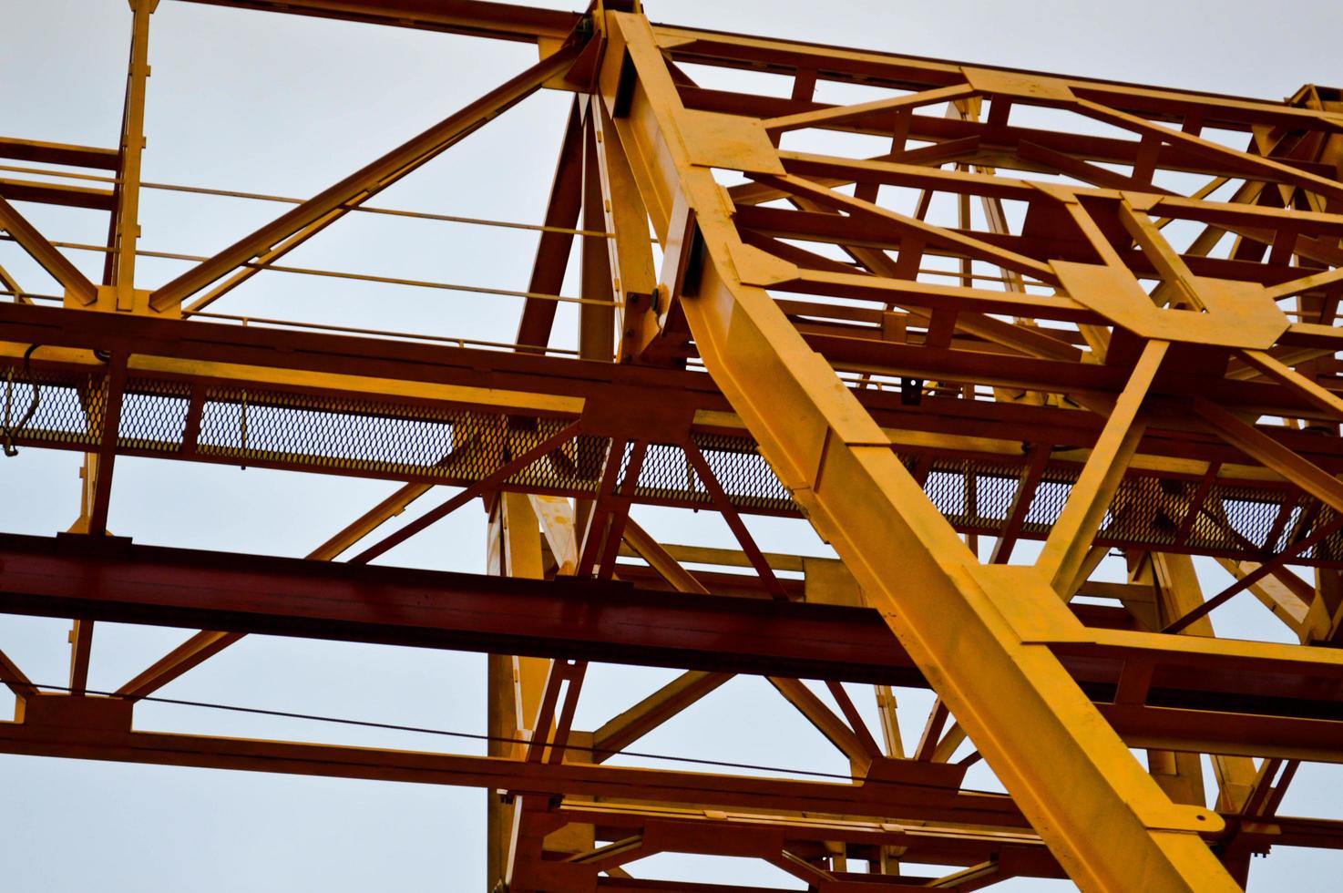 High heavy yellow metal iron load-bearing construction stationary industrial powerful gantry crane of bridge type on supports for lifting cargo on a modern construction site of buildings and houses photo