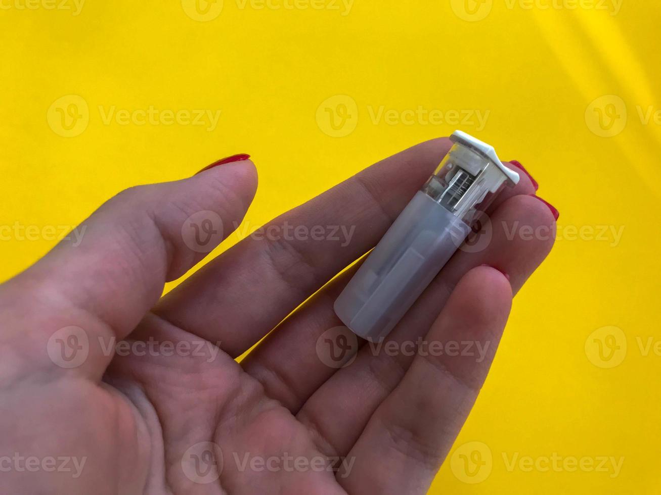 small white lancet on a yellow bright background. finger puncture. medical procedure for health