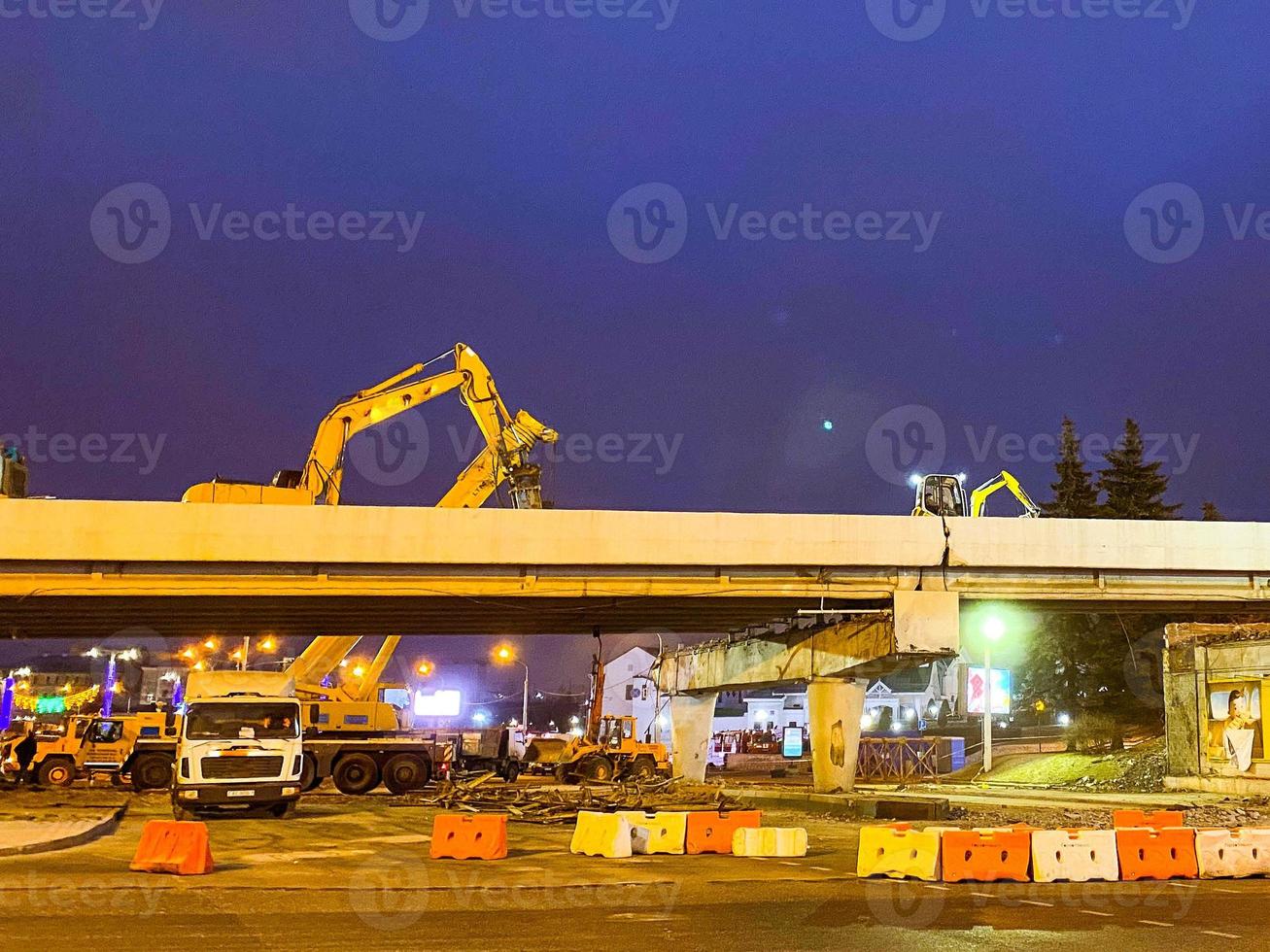 construcción de un puente en el centro de la ciudad. el paso elevado se ha agrietado y lo están reparando por la noche. equipo de construcción, las grúas están de pie alrededor foto