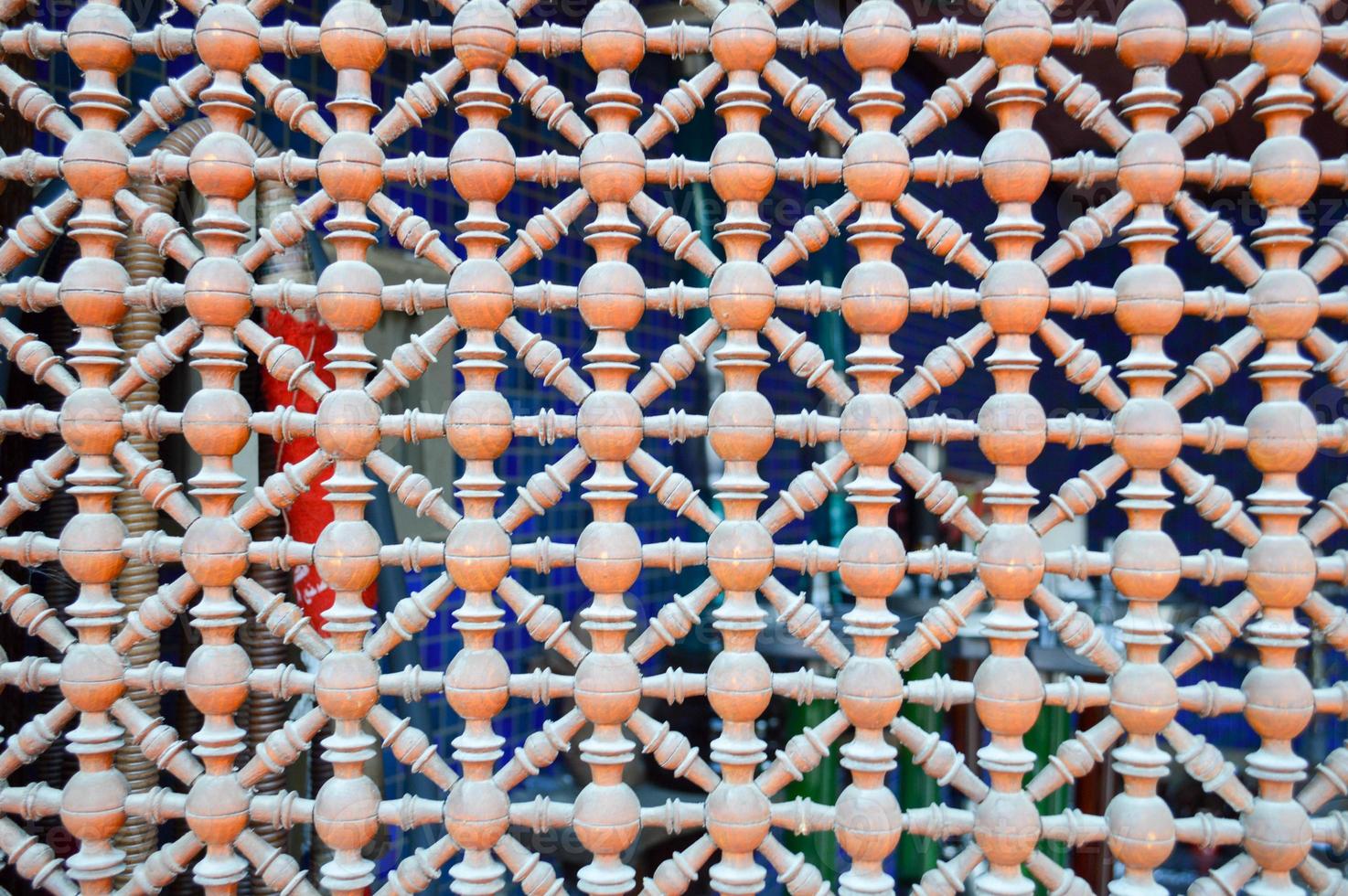 Texture of a wooden brown grating with holes on the window in Arabic style. The background photo