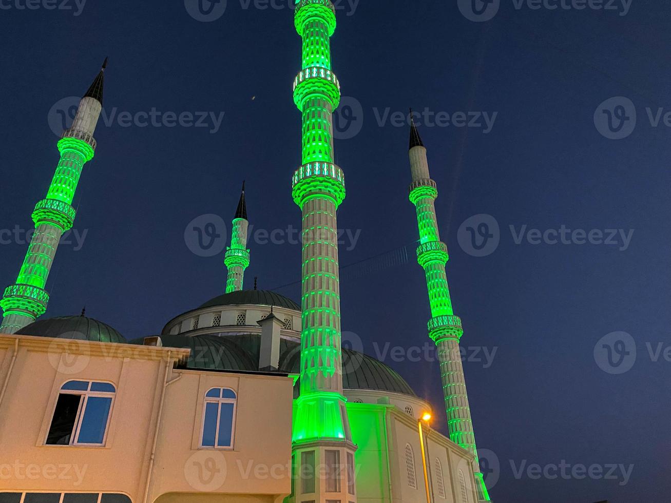 grande y hermosa mezquita musulmana alta templo islámico para rezar a dios allah con torres de alta religión en el cálido complejo tropical del este del país por la noche foto