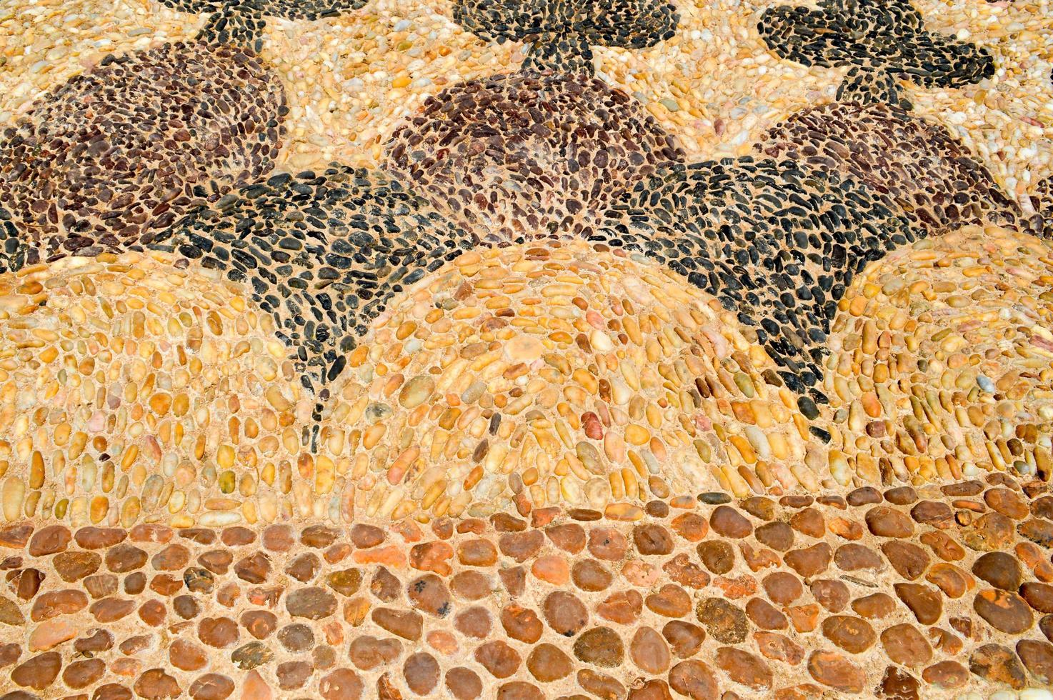 The texture of the stone wall, the road from small round and oval stones with abstract lines laid out patterns of sandy seams of natural old yellow black brown. The background photo