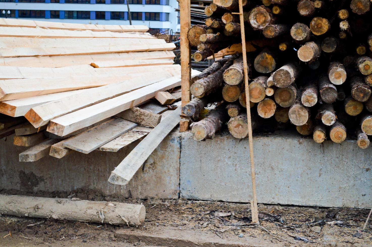 un montón de troncos y tableros cepillados naturales de madera largos en un aserradero. el fondo. textura. cosecha de madera conceptual para la industria de la madera foto