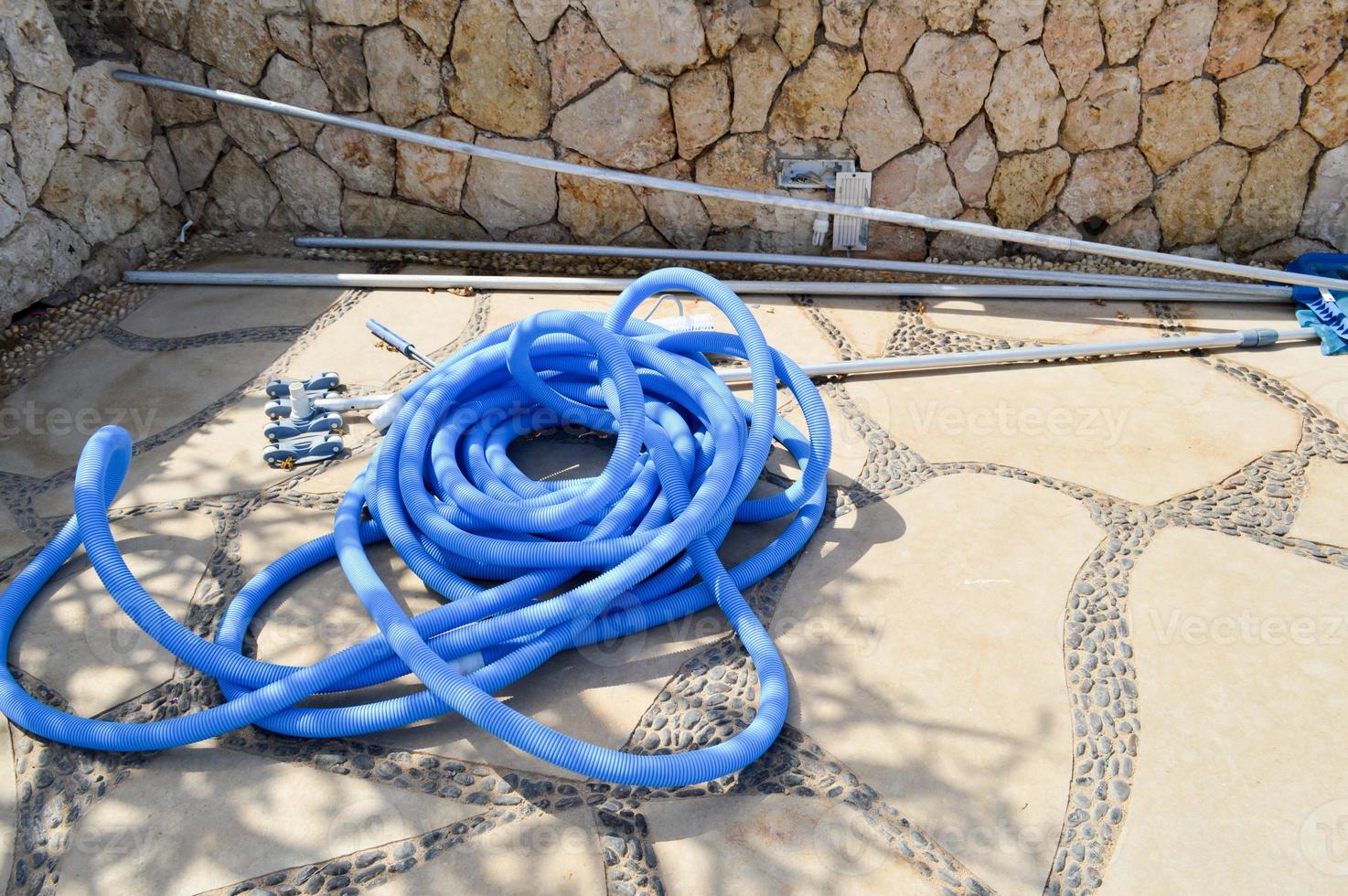 Blue plastic long large corrugated hose for cleaning the pool wash and watering the plants photo
