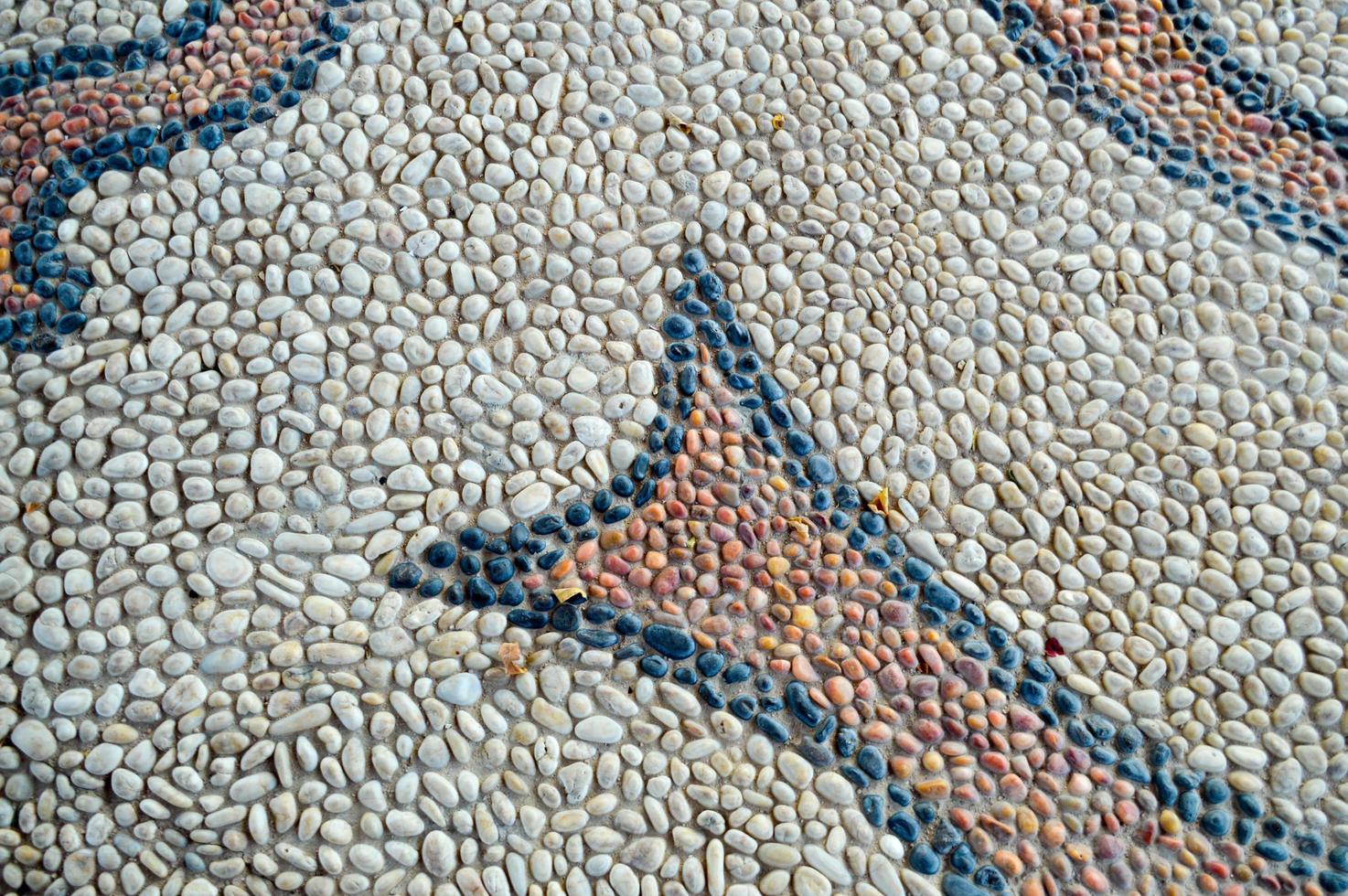 The texture of the stone wall, the road from small round and oval stones with abstract lines laid out patterns of sandy seams of natural old yellow black brown. The background photo