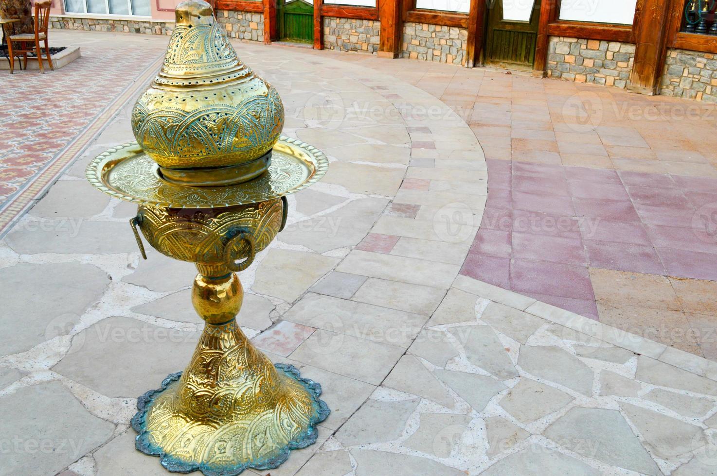 A special golden iron yellow metallic container for storing hot, dissociated coals for a traditional hookah in Egypt photo