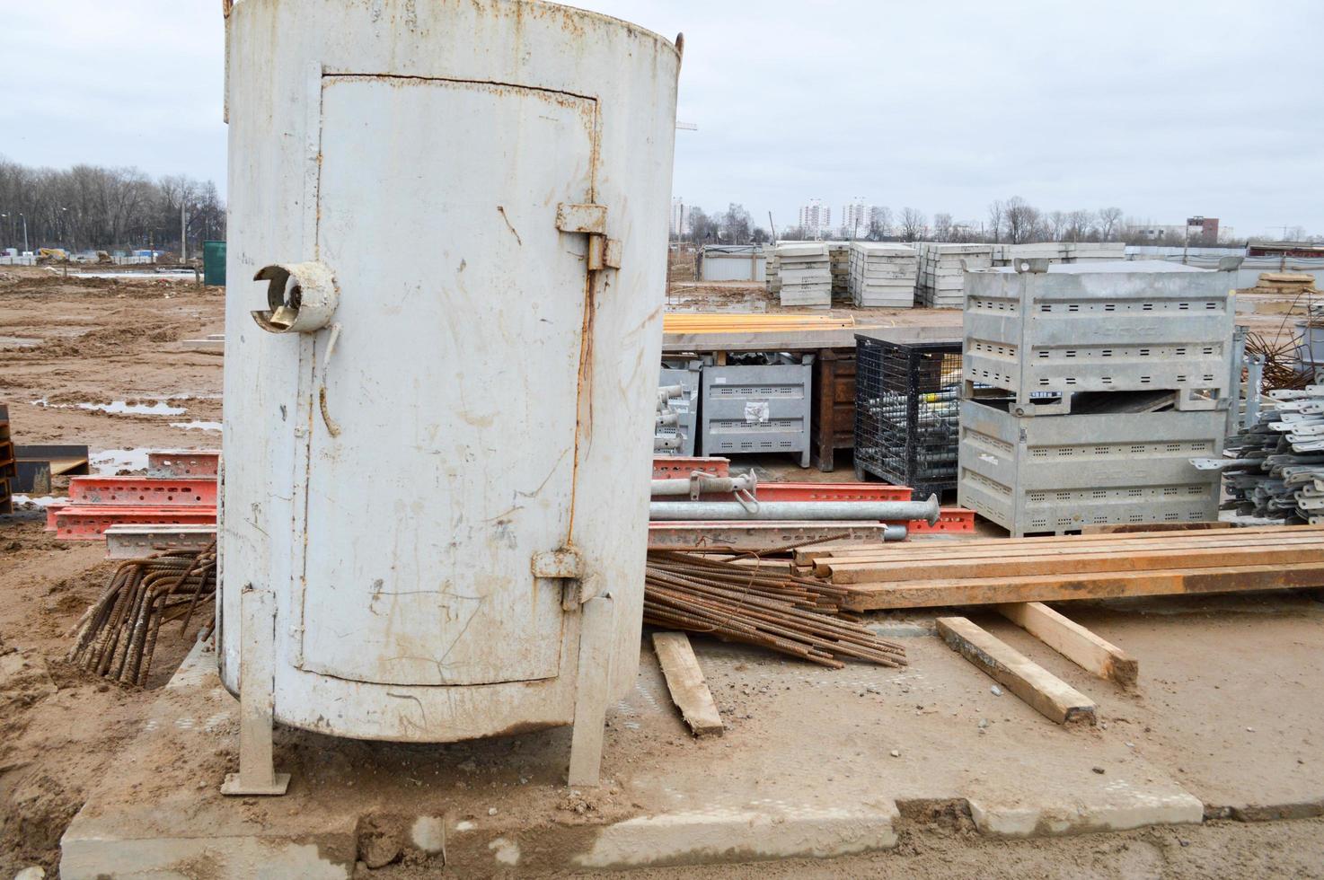 A lot of building materials with metal spare parts, sticks, beams, pipes at an open-air construction site warehouse photo