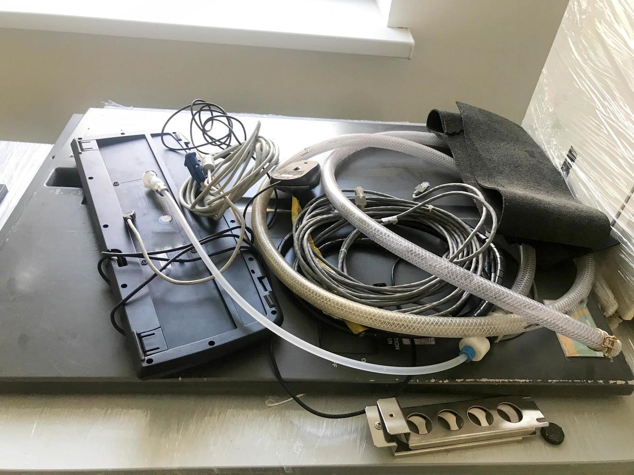 Many different industrial hoses and wires lie on the table photo