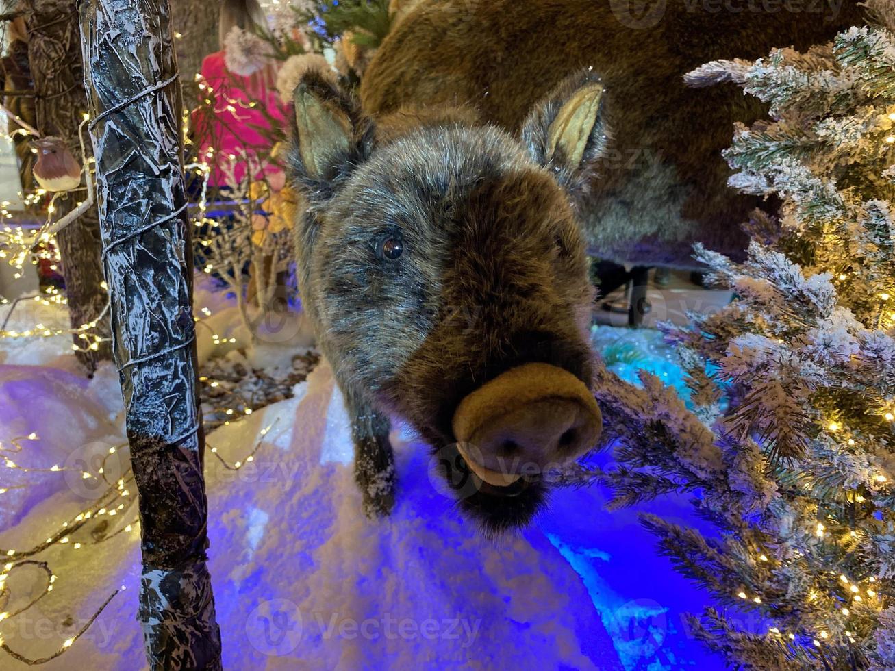 Christmas decoration with toy wild boar, small christmas tree and lights garland. Christmas and Happy New Year concepts. Image for design photo