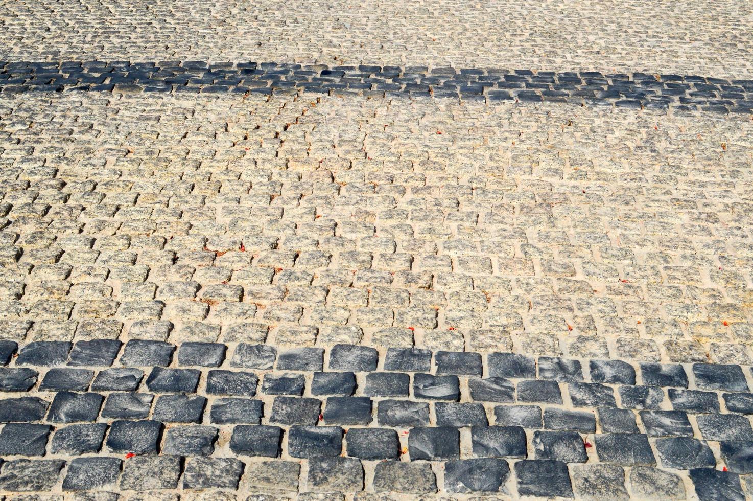 Texture of a stone wall, roads from stones, bricks, cobblestones, tiles with sandy seams of gray ancient natural old yellow with sharp edges. The background photo