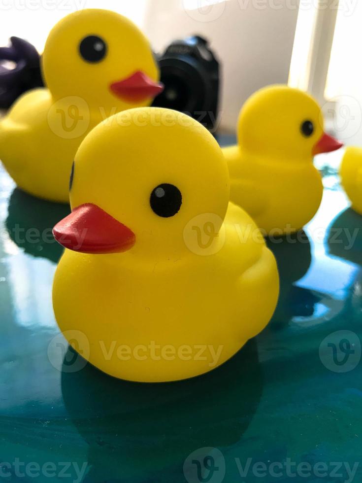 yellow rubber ducks floating on the water of epoxy blue resin. glare on the interior picture. family of ducks made for swimming with children. Cute bathroom decorations photo