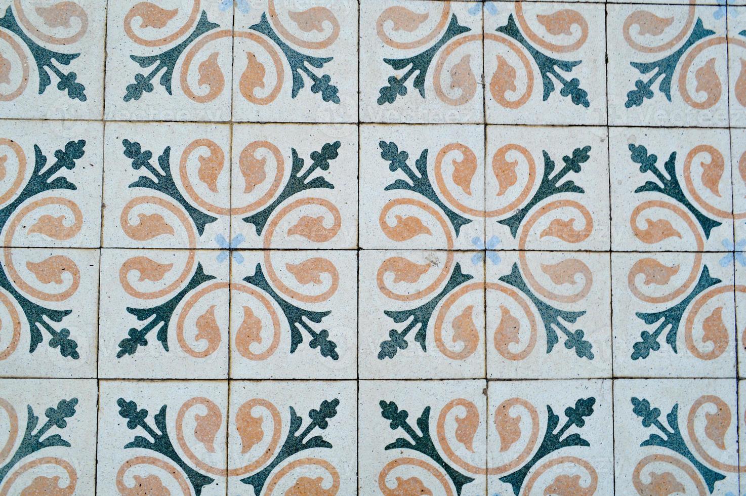 The texture of square ceramic tiles with patterns from traditional Arabic ornaments and flowers of yellow and blue with seams. The background photo