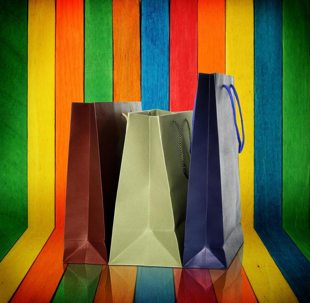 Bolsas de compras sobre fondo de madera de colores foto