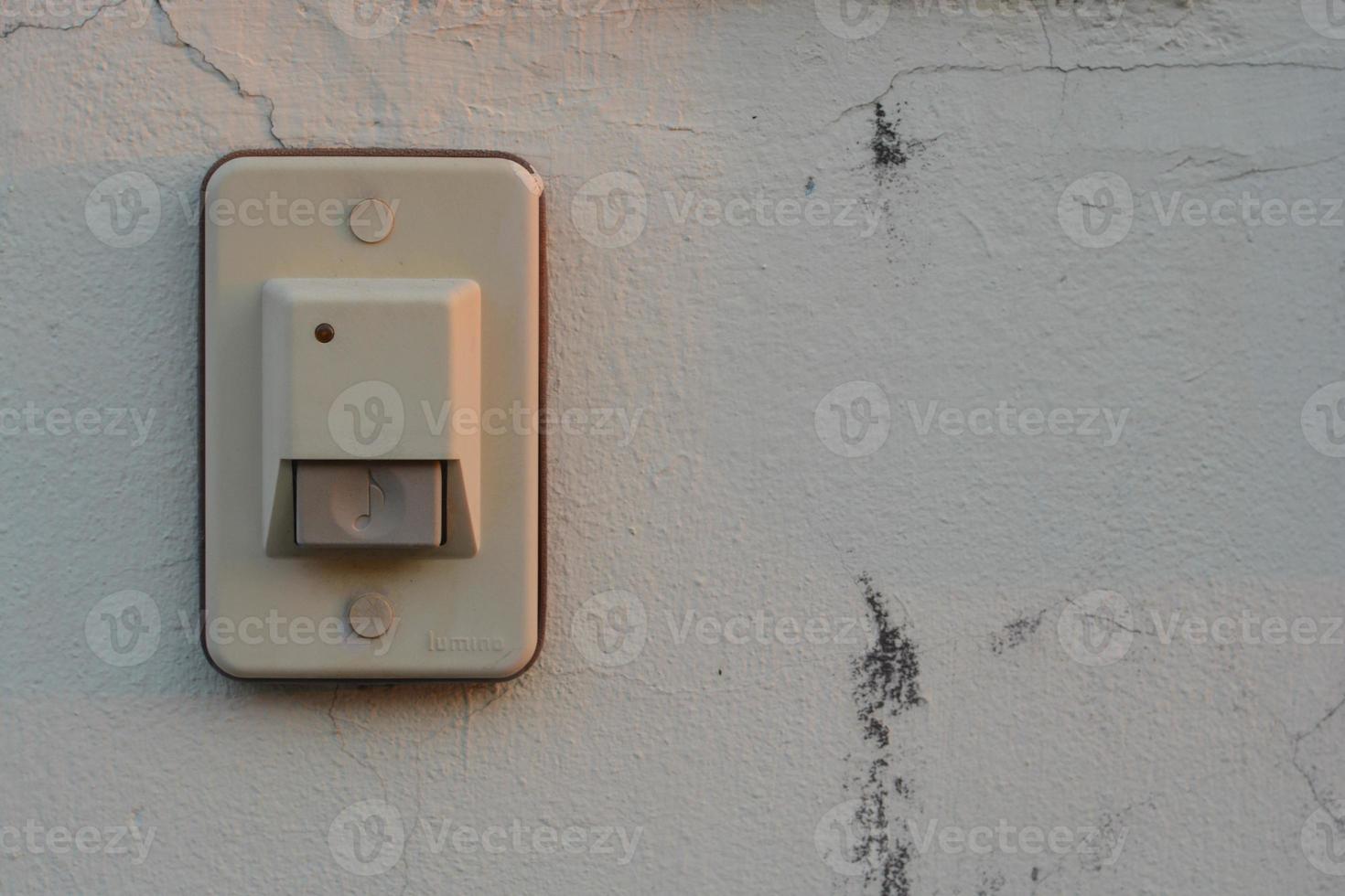 White doorbell on the old wall of the house. photo